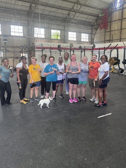 Smiling group after a workout, with a small dog