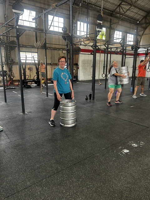 A member carrying a weight during a functional fitness class