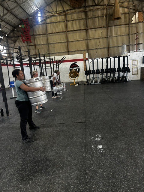 A member carrying weights during a Moving with Monique class